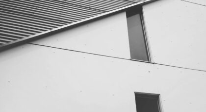 Abstract black-and-white view of a modern concrete building's facade showcasing minimalist design elements.