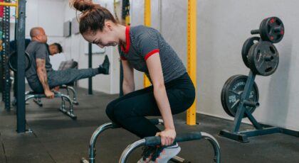 Focused group of young adults exercising intensely with gym equipment indoors.