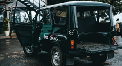 A rugged off-road vehicle parked outdoors on a rainy day with open doors and Lang Biang branding.