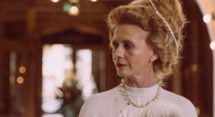 A sophisticated woman with a Maltese dog at a luxurious hotel lobby, exuding class and elegance.