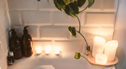 Relax in a cozy bathtub with candles, tea, and a book for a serene evening.