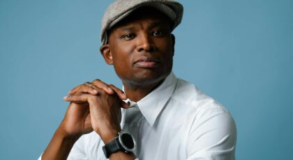 Portrait of a stylish man in classic fashion, wearing a flat cap and white shirt.