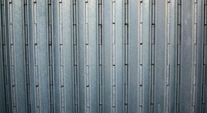 Close-up of a grey corrugated metal surface showcasing its uniform pattern and sturdy construction.