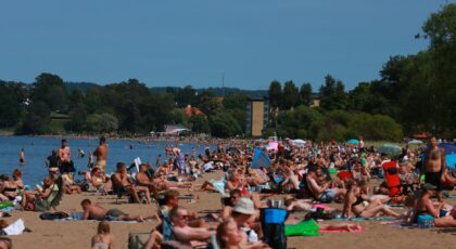 A vibrant summer day at a crowded beach in Jönköping, Sweden, perfect for relaxation and fun.