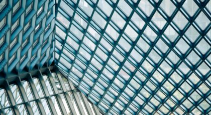 Intricate design of a glass and steel framework showcasing modern architecture indoors.