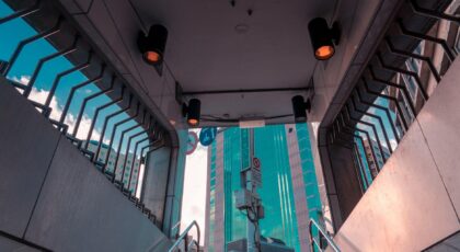 A modern city subway entrance contrasting with towering skyscrapers above.