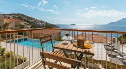 Enjoying summer drinks on a sunny seaside balcony with stunning ocean views.