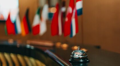 Sophisticated hotel lobby with a reception bell and array of international flags in focus.