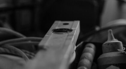 Black and white image of construction tools in a workshop, emphasizing a spirit level.