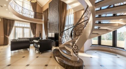 Elegant modern living room featuring a grand spiral staircase and luxurious decor.