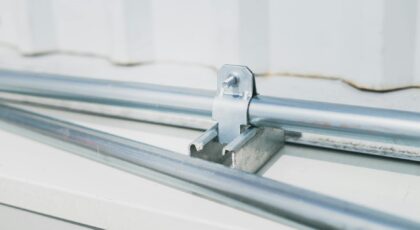 Detailed close-up of a metal pipe clamp on a stainless steel surface, highlighting industrial design.