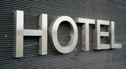 Close-up of a metallic hotel sign mounted on a textured wall.