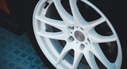 Detailed close-up of a white alloy car wheel showcasing design and craftsmanship.