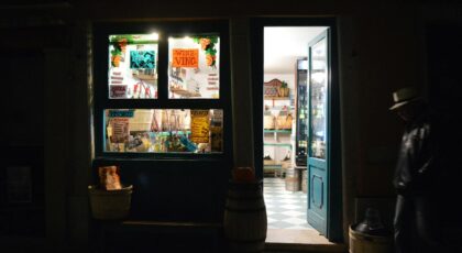 Charming night view of a Venetian shop with open door and warm lighting invites a mysterious ambiance.