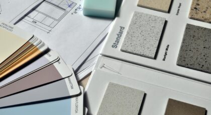 Color palette and material samples for interior renovation projects on a blueprint.