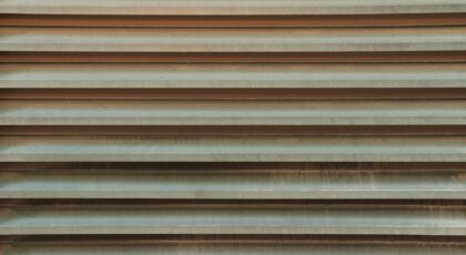 Close-up view of a rustic corrugated metal pattern surface, showcasing texture and design.