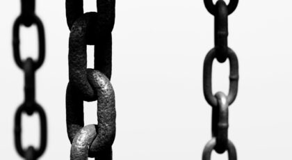 Artistic black and white photo of hanging chains, focusing on texture and connection.