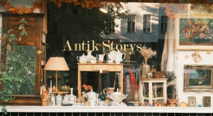 Charming vintage store window showcasing antiques and collectibles in an autumn setting.