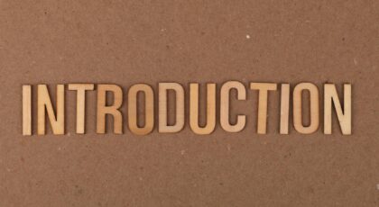 Wooden letters spelling 'INTRODUCTION' placed on a cardboard background.