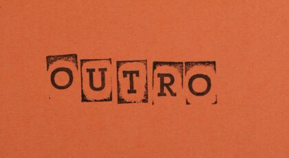 Close-up of the word OUTRO stamped on orange paper, highlighting typography and design.