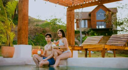 A couple enjoying drinks by the pool at a tropical resort, capturing a relaxing summer vacation vibe.