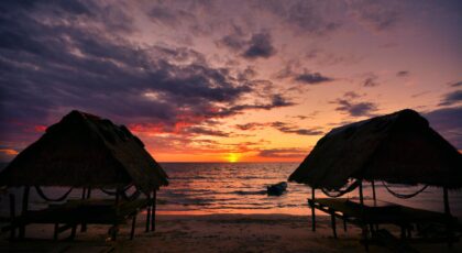 Tranquil beach sunset with cabanas in Koh Kong Province, Cambodia.